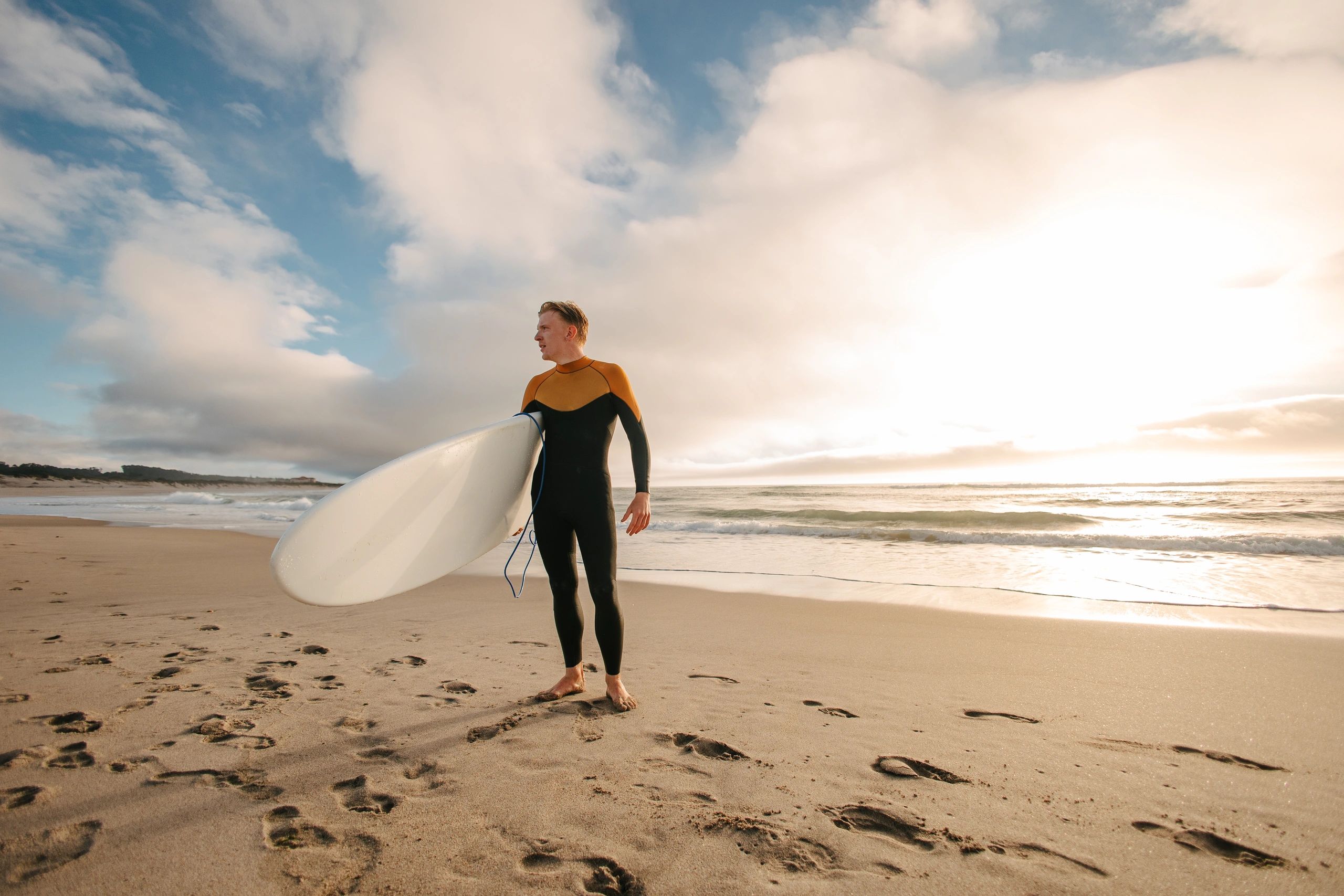 Surfer holding a surfboard on a Portuguese beach